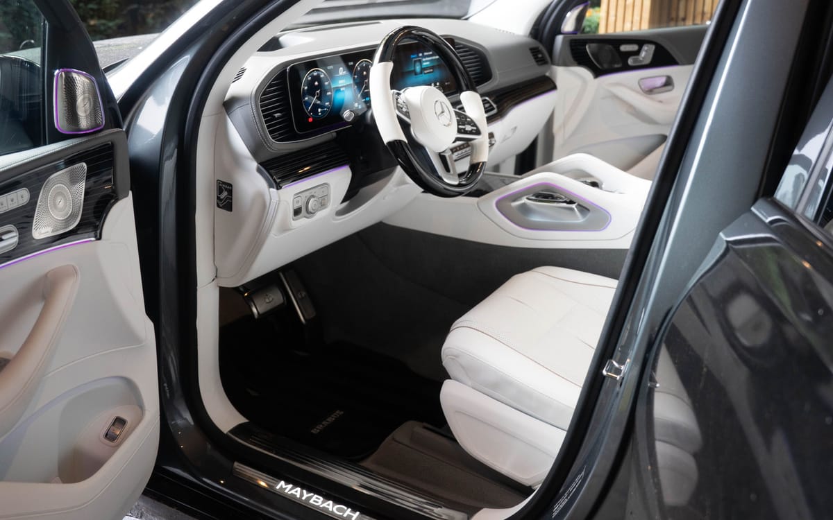 Schoon, wit lederen interieur van een Maybach met verlichte instaplijst