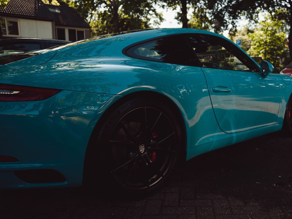 Glanzende achterflank van een turquoise Porsche 911